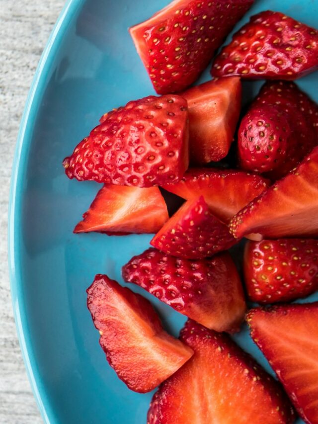 sliced strawberries on teal ceramic plate