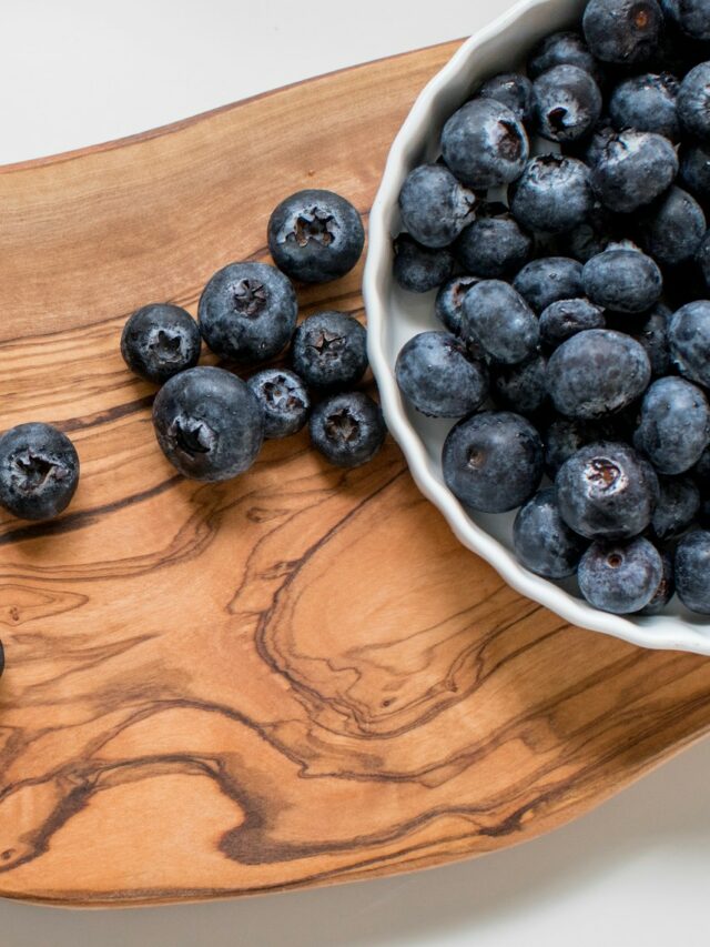 black berries on brown wooden chopping board