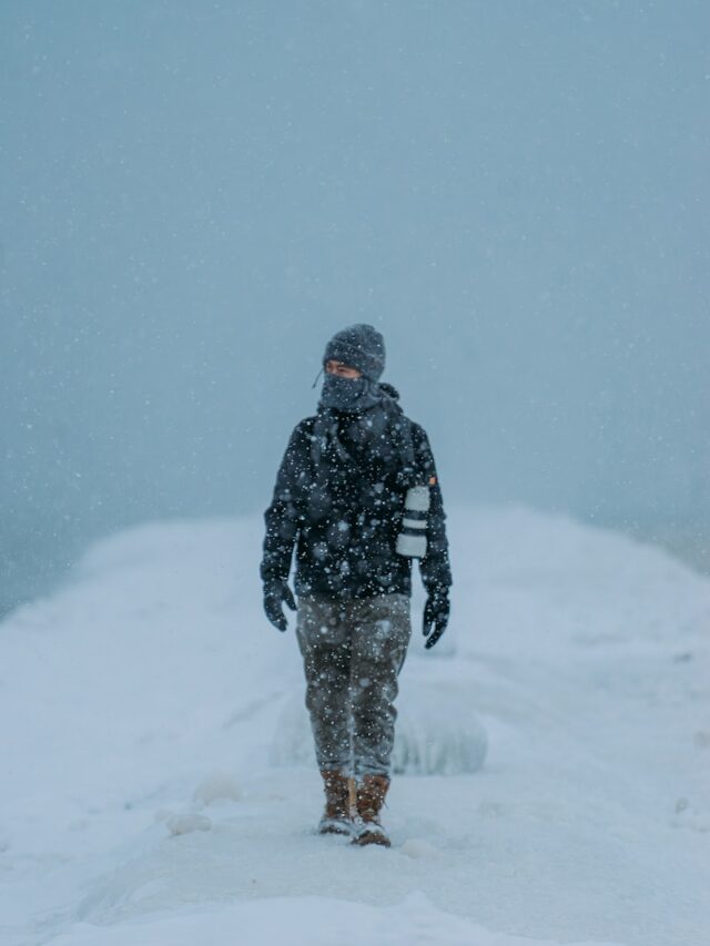 A person walking in the snow in the middle of the day