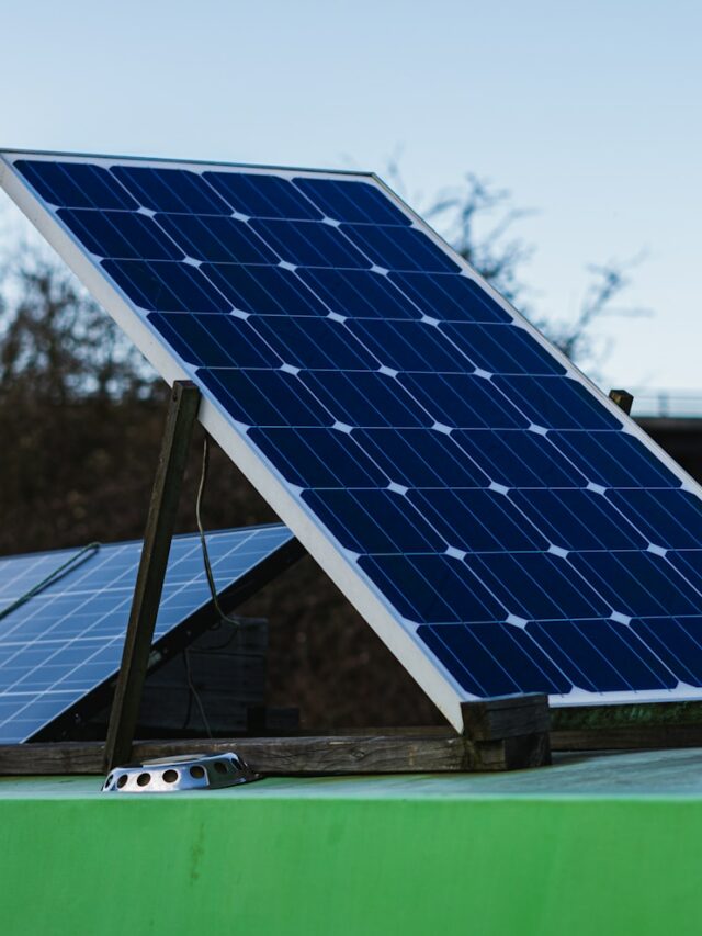 blue and white solar panel on green metal bar during daytime