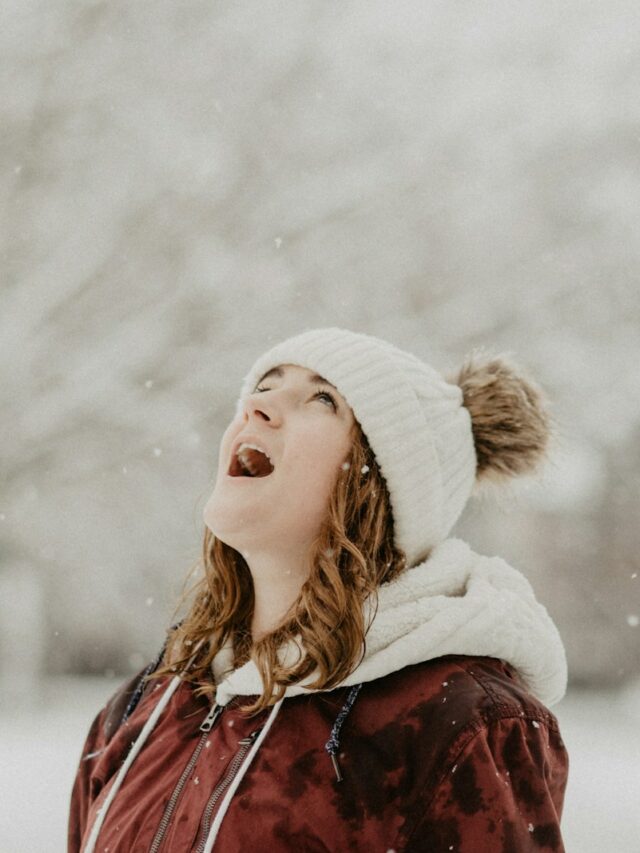 woman wearing bobble cap looking upwards selective focus photography