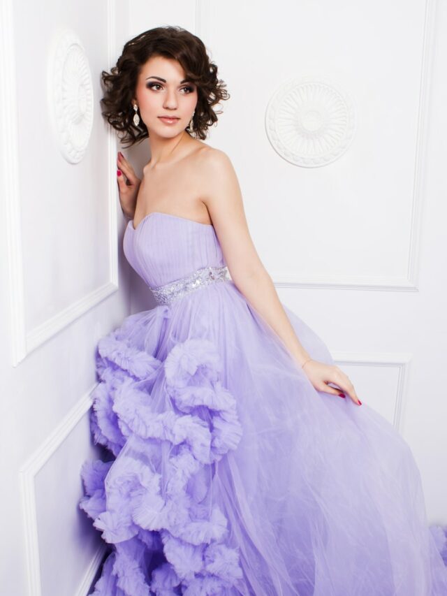 woman in purple strapless wedding dress leaning on wall