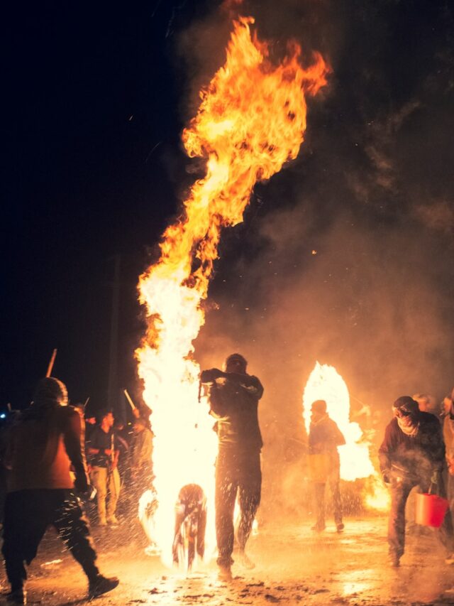 A group of people standing around a fire