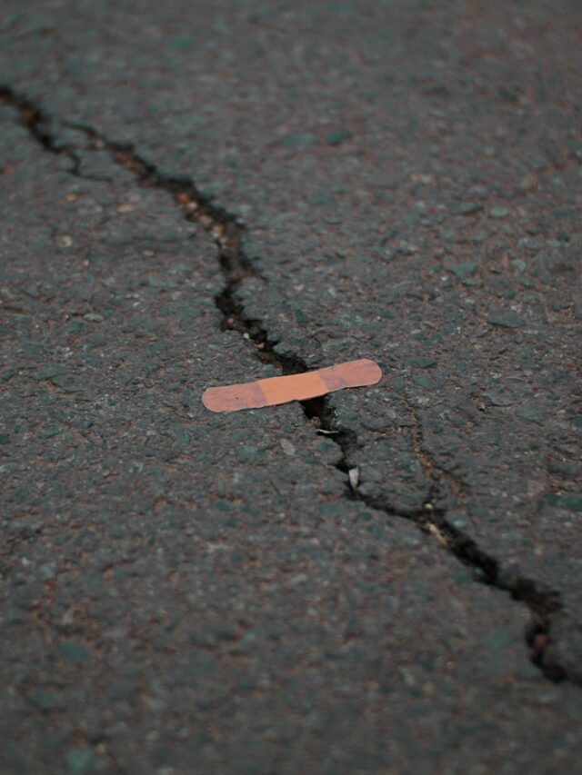 orange band aid on concrete surface crack