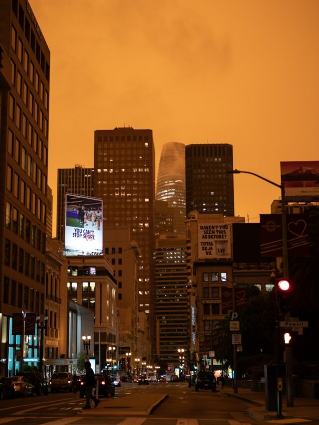 city buildings under orange sky during sunset