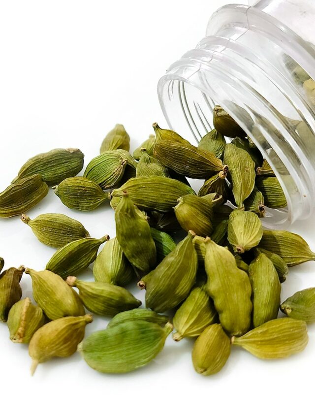 a pile of pistachio seeds next to a bottle of water