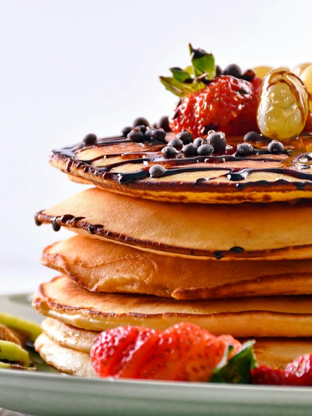 a stack of pancakes with fruit on top