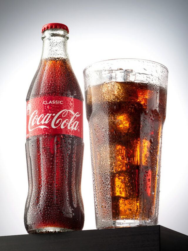 coca cola bottle beside drinking glass