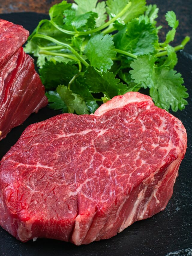 Two steaks on a plate with parsley