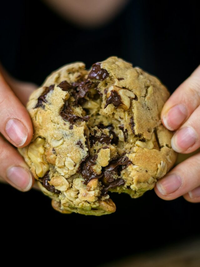 a person holding a cookie in their hands