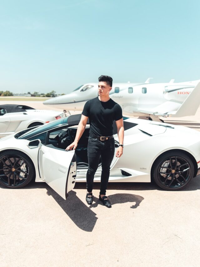 man in black by a white sports car