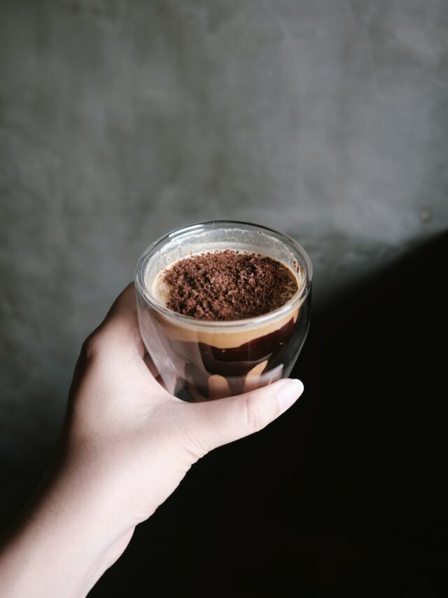 a person holding a cup of coffee in their hand