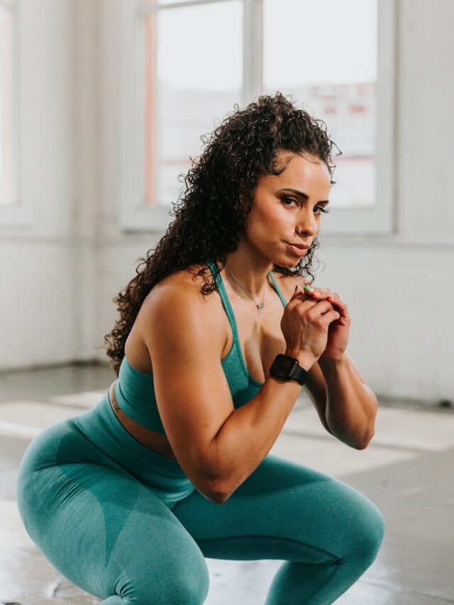 a woman squatting on the ground with her hands clasped