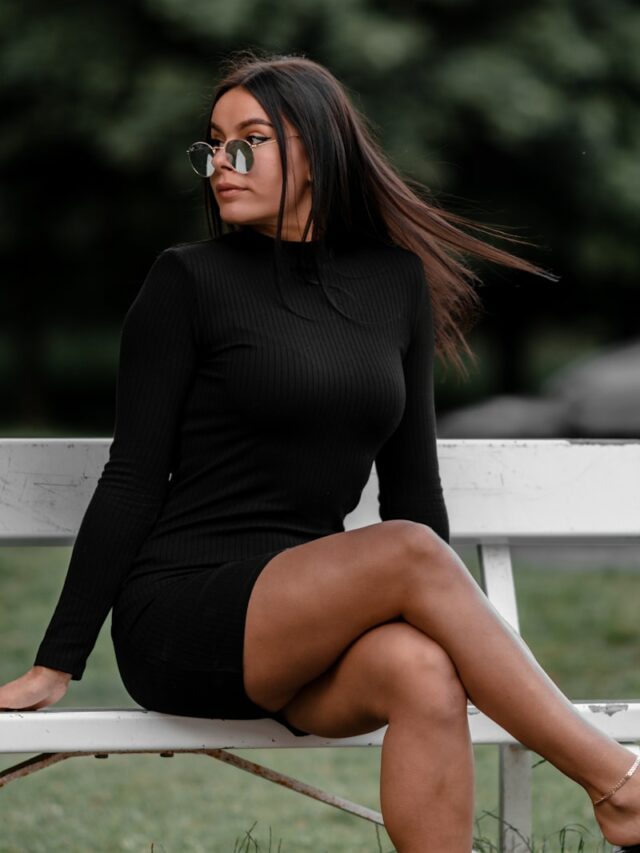 woman in black long sleeve shirt sitting on white wooden bench during daytime