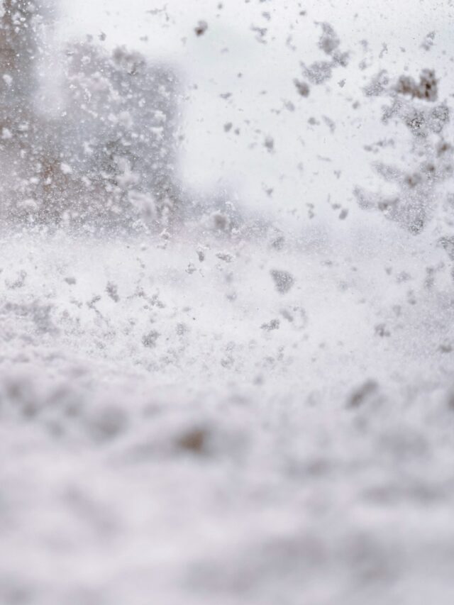 a snow covered street with a building in the background